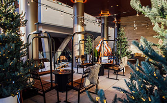 Cypress Terrace with ski lift chair seating, fire pits and pine trees with twinkle lights